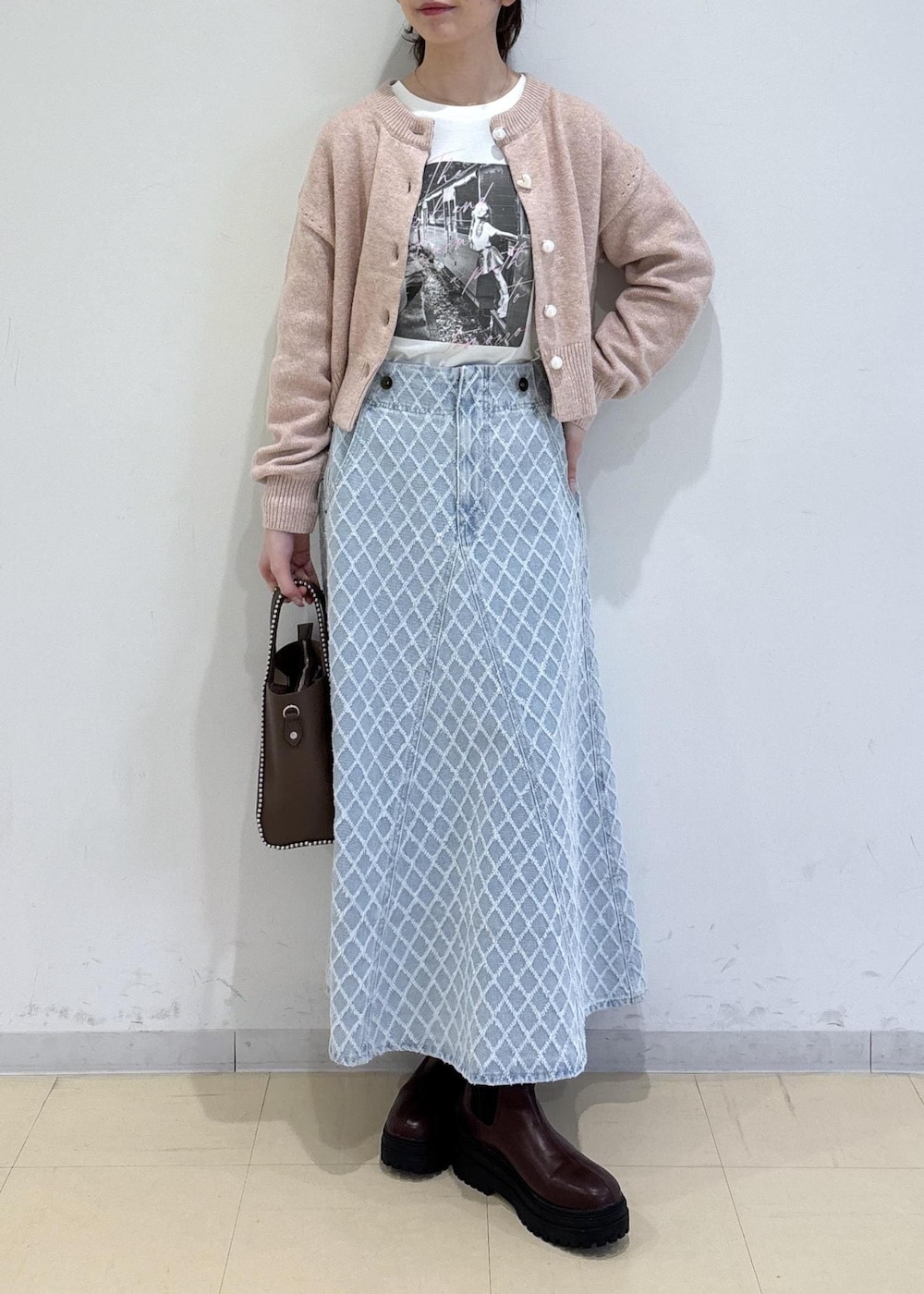 ブラウン系のブーツ、ピンク系のカーディガン/ボレロ、ブラウン系のトートバッグを着用したレディースの冬コーディネートの2枚目の写真