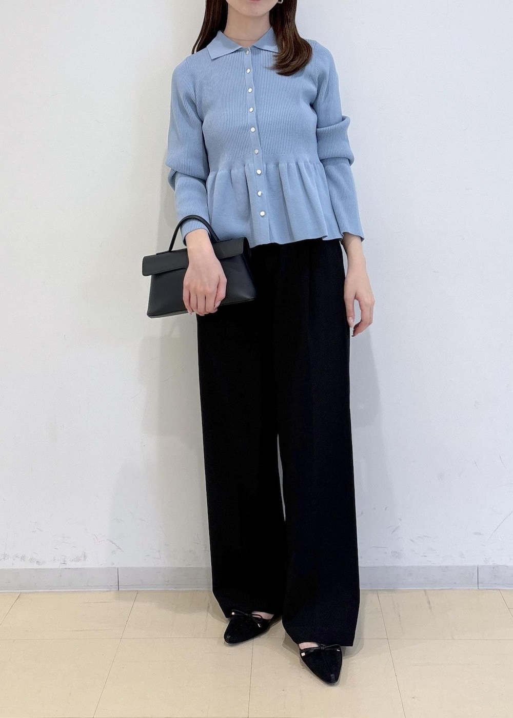 ブラック系のショルダーバッグ、ブラック系のパンプス、ブルー系のカーディガン/ボレロを着用したレディースの秋コーディネートの2枚目の写真