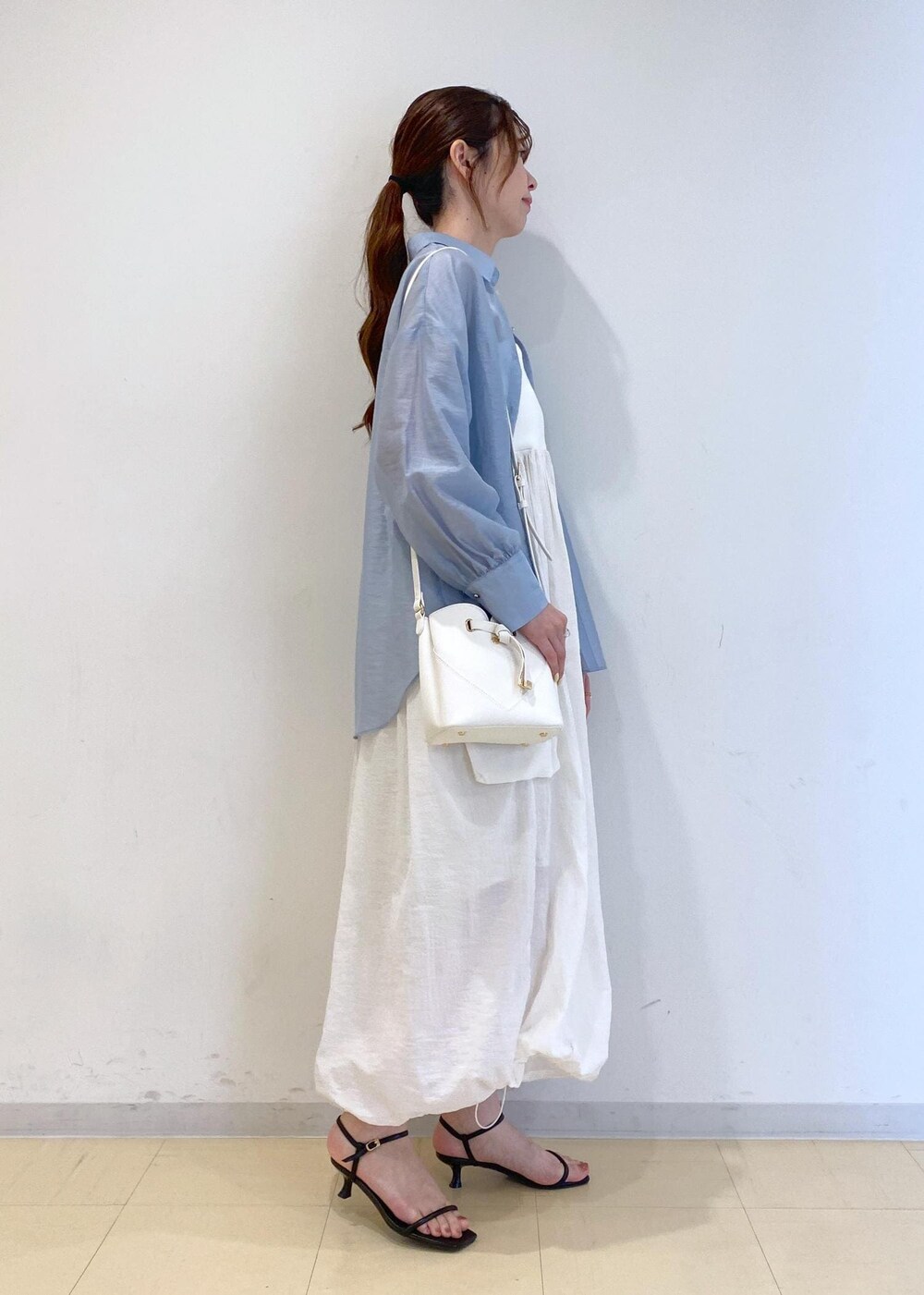 ブラック系のサンダル、ホワイト系のワンピース、ブルー系のシャツ/ブラウスを着用したレディースの夏コーディネートの3枚目の写真