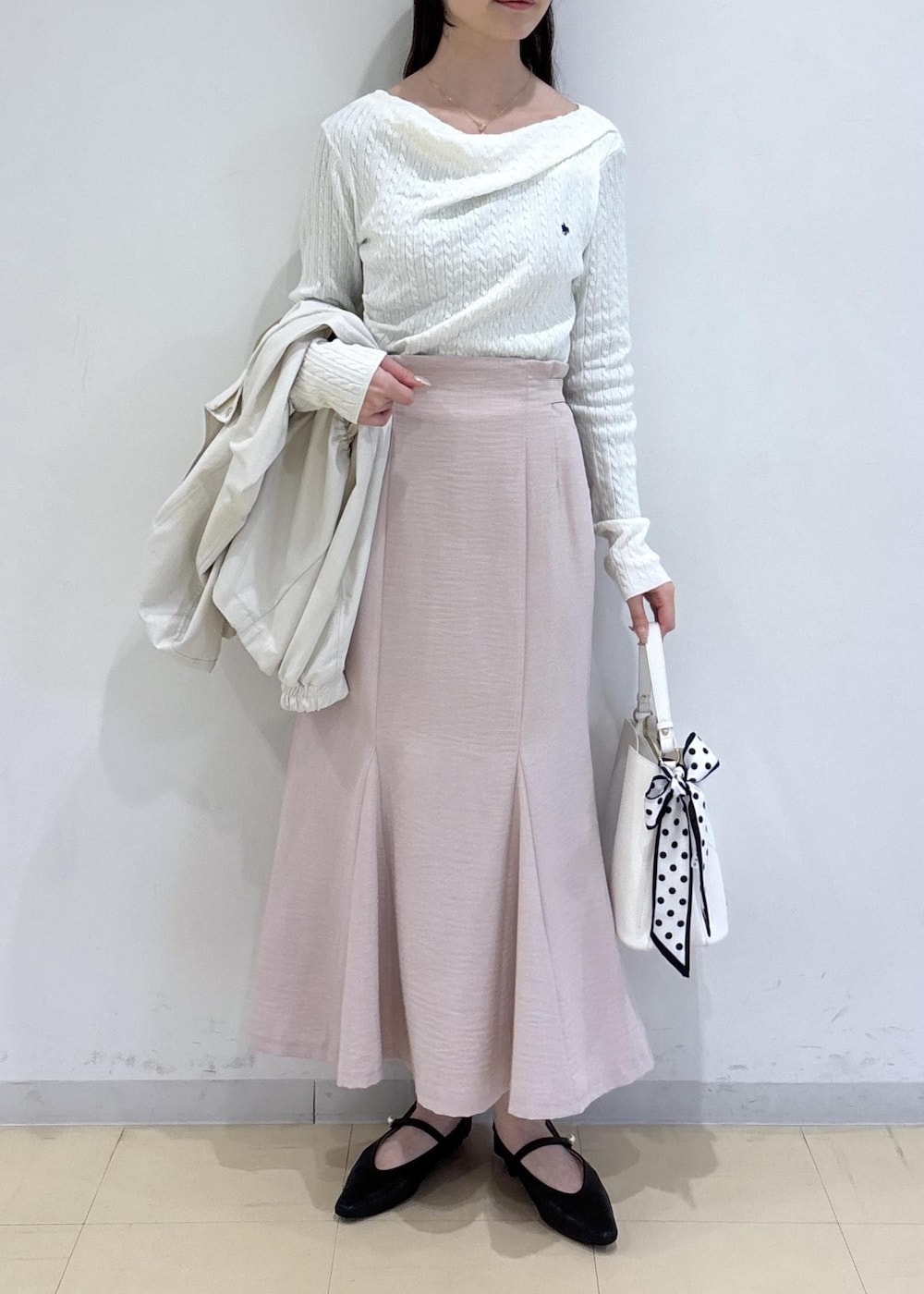 ホワイト系のショルダーバッグ、ブラック系のパンプス、ホワイト系のナイロンジャケットを着用したレディースの春コーディネートの4枚目の写真