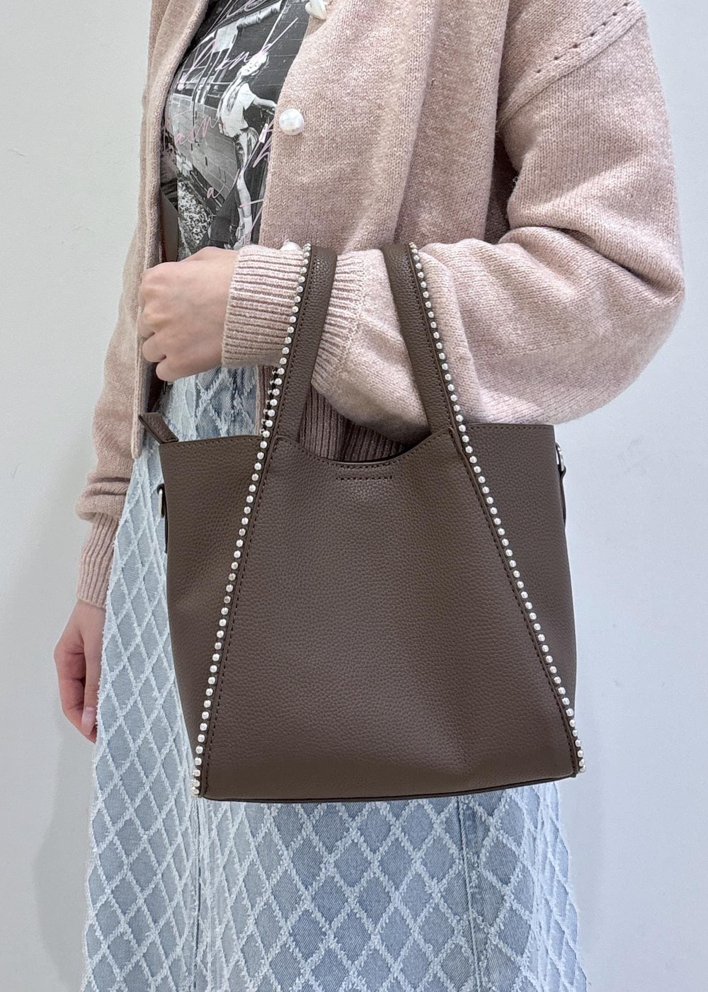 ブラウン系のブーツ、ピンク系のカーディガン/ボレロ、ブラウン系のトートバッグを着用したレディースの冬コーディネートの9枚目の写真