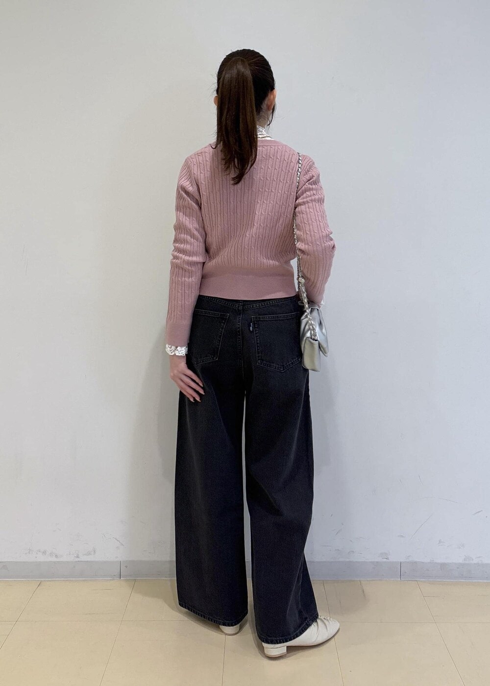 ホワイト系のパンプス、グレー系のデニムパンツ、ホワイト系のTシャツ/カットソーを着用したレディースの冬コーディネートの4枚目の写真