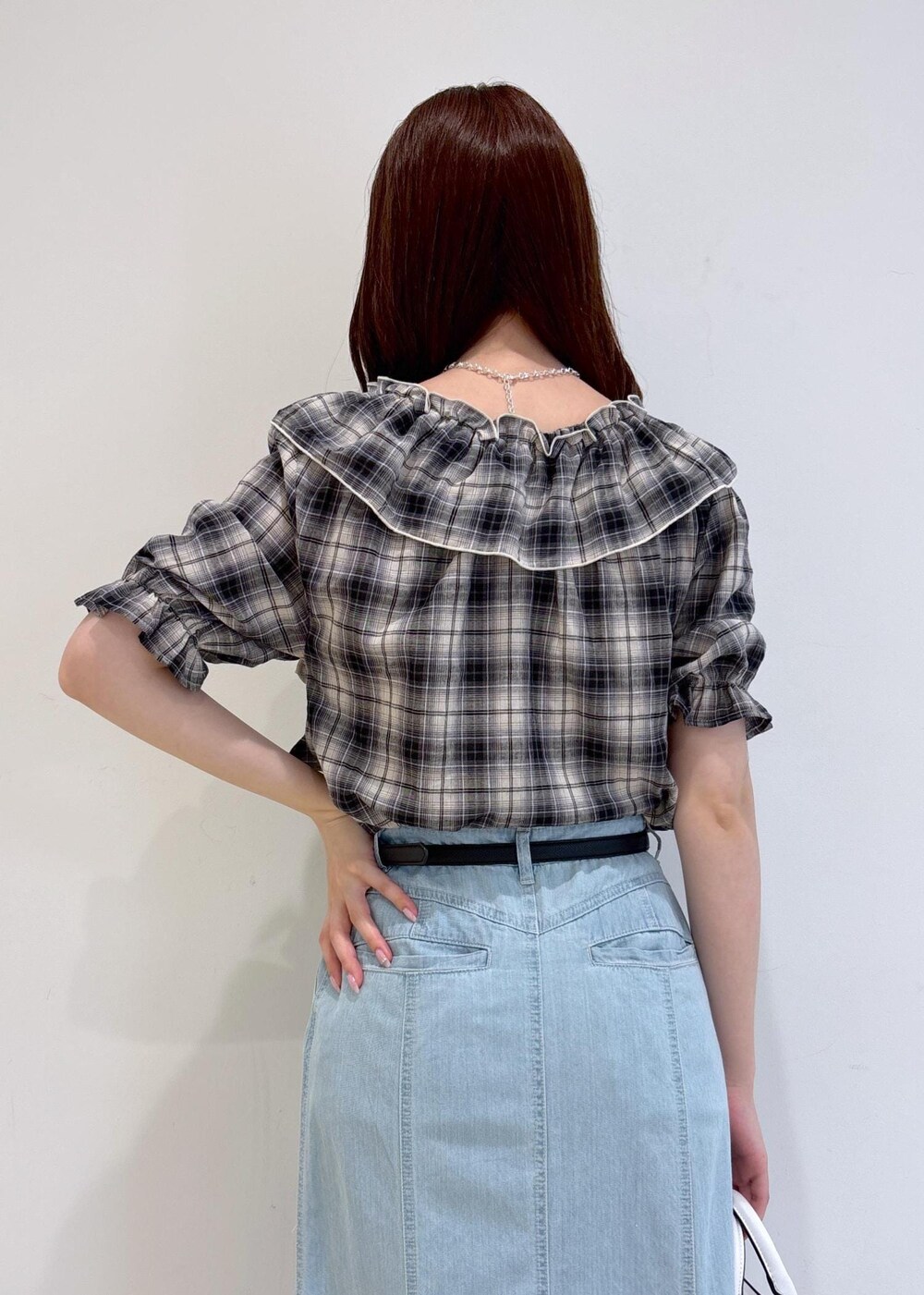 ブラック系のサンダル、ブルー系のデニムスカート、ホワイト系のショルダーバッグを着用したレディースの夏コーディネートの7枚目の写真