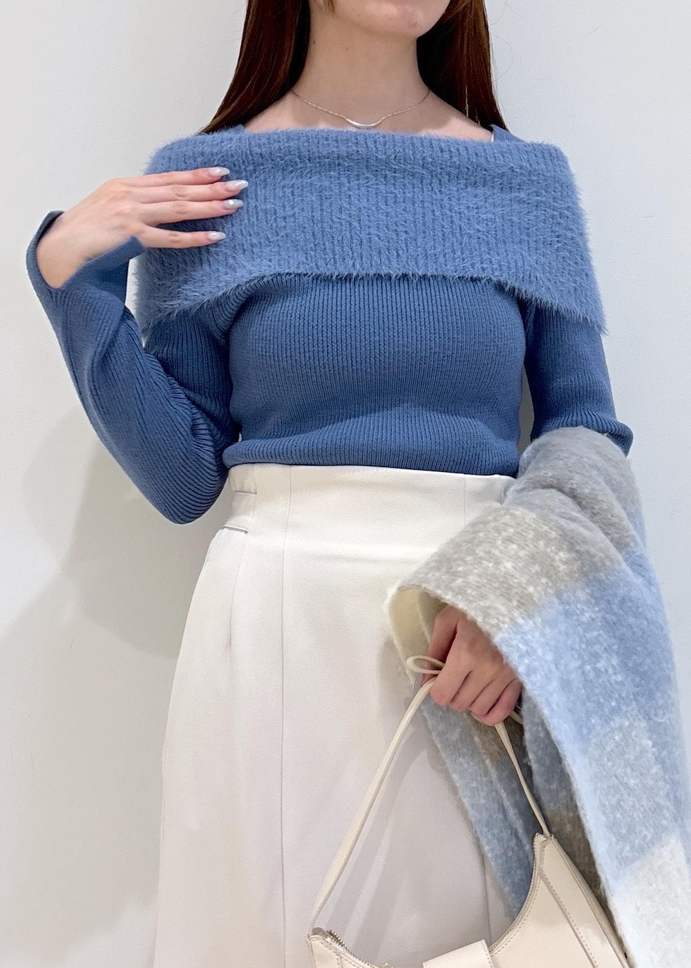 ホワイト系のショルダーバッグ、ブラック系のブーツ、ブルー系のニット/セーターを着用したレディースの秋コーディネートの5枚目の写真