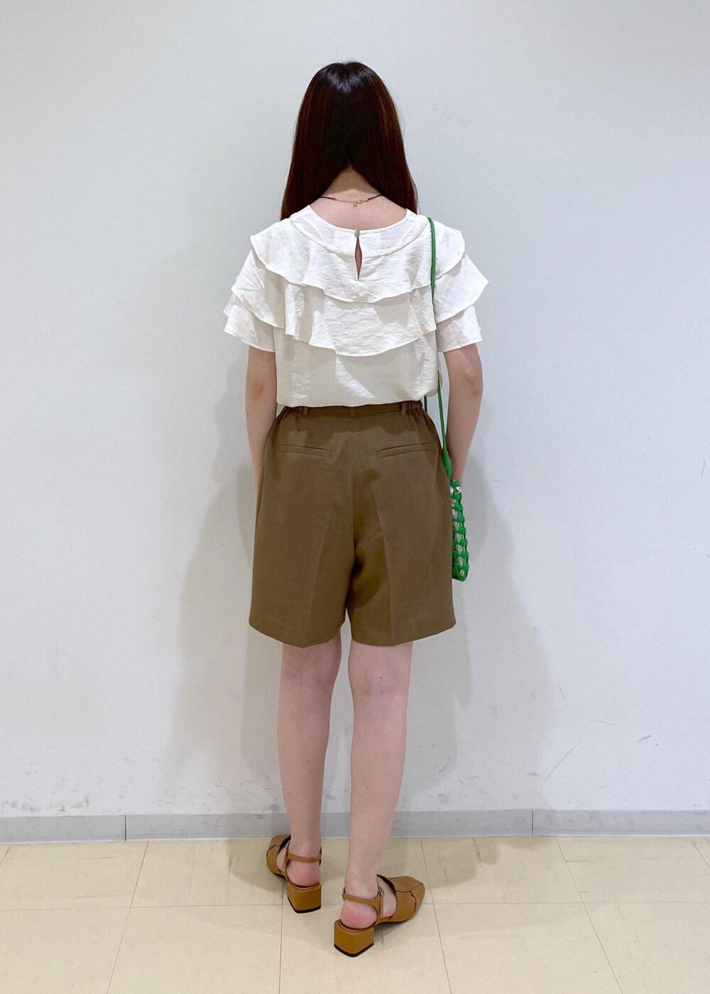 イエロー系のサンダル、ホワイト系のシャツ/ブラウス、グリーン系のショルダーバッグを着用したレディースの夏コーディネートの4枚目の写真