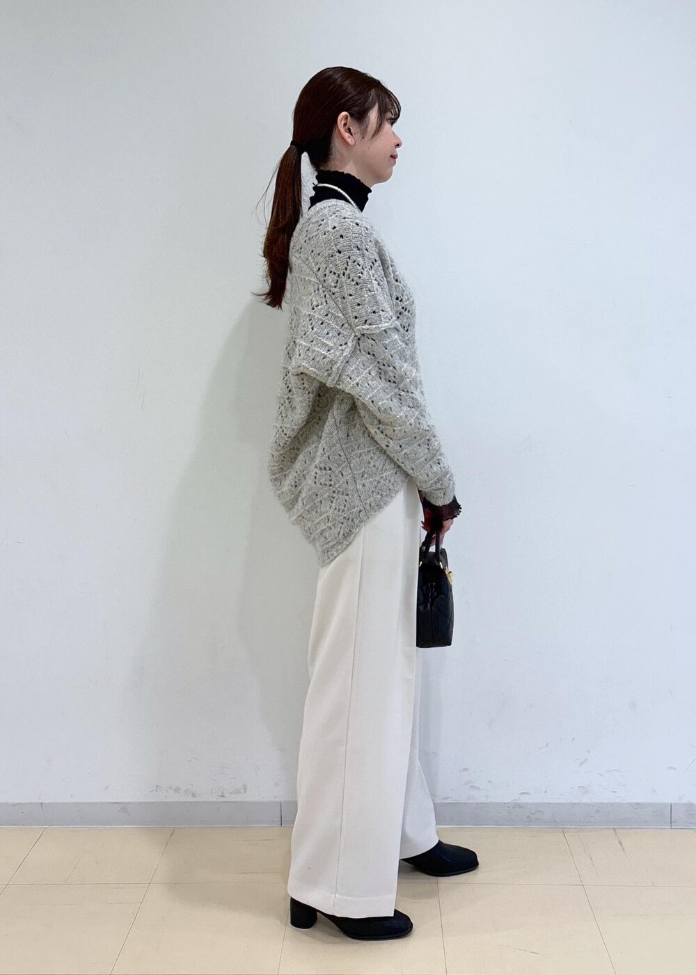 ブラック系のブーツ、ブラック系のTシャツ/カットソー、ベージュ系のニット/セーターを着用したレディースの冬コーディネートの3枚目の写真