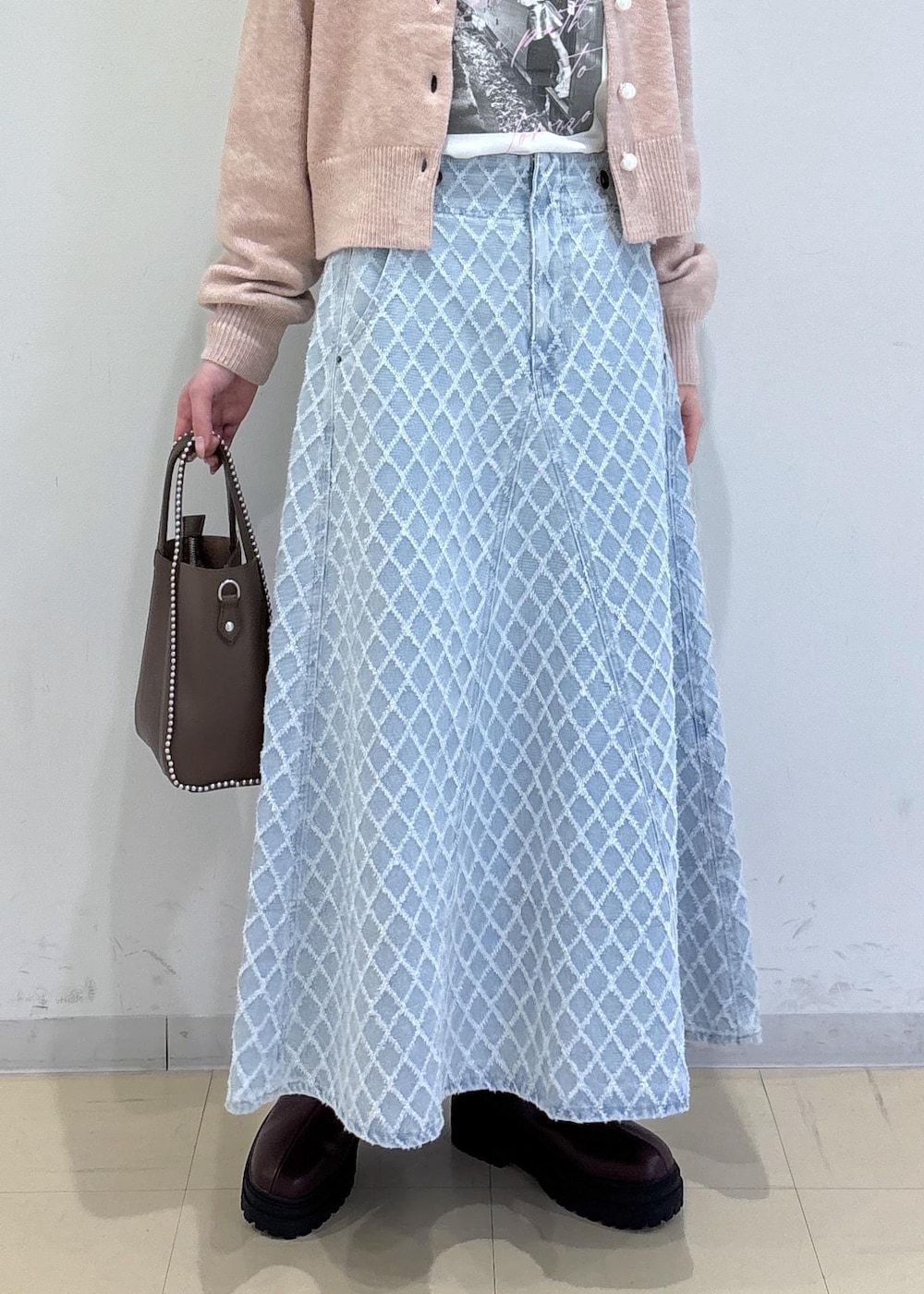 ブラウン系のブーツ、ピンク系のカーディガン/ボレロ、ブラウン系のトートバッグを着用したレディースの冬コーディネートの5枚目の写真