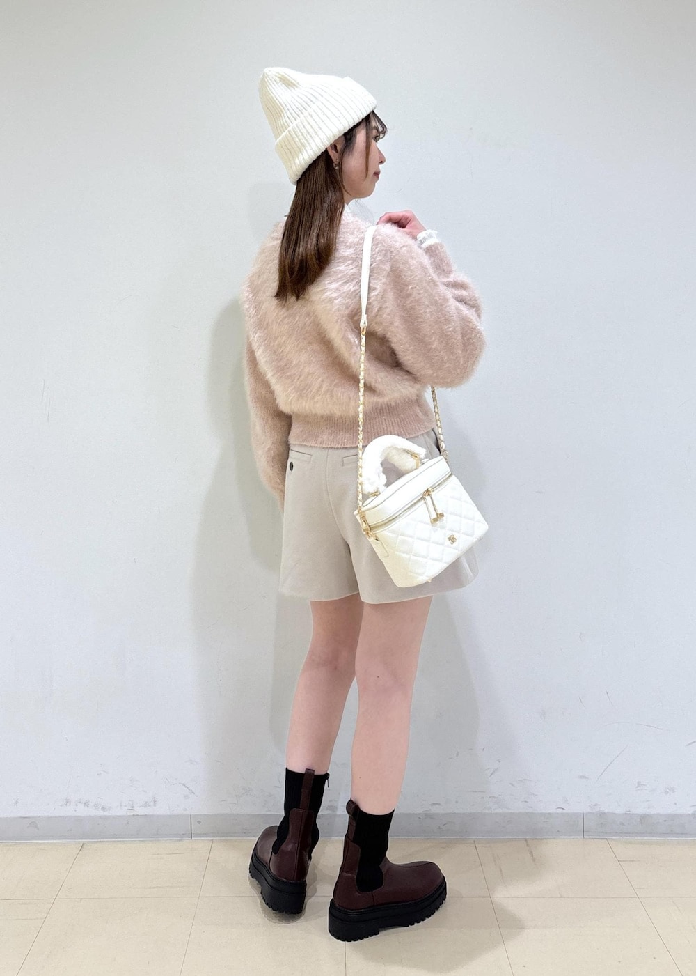 ブラウン系のブーツ、ベージュ系のその他パンツ、ホワイト系のハンドバッグを着用したレディースの冬コーディネートの4枚目の写真