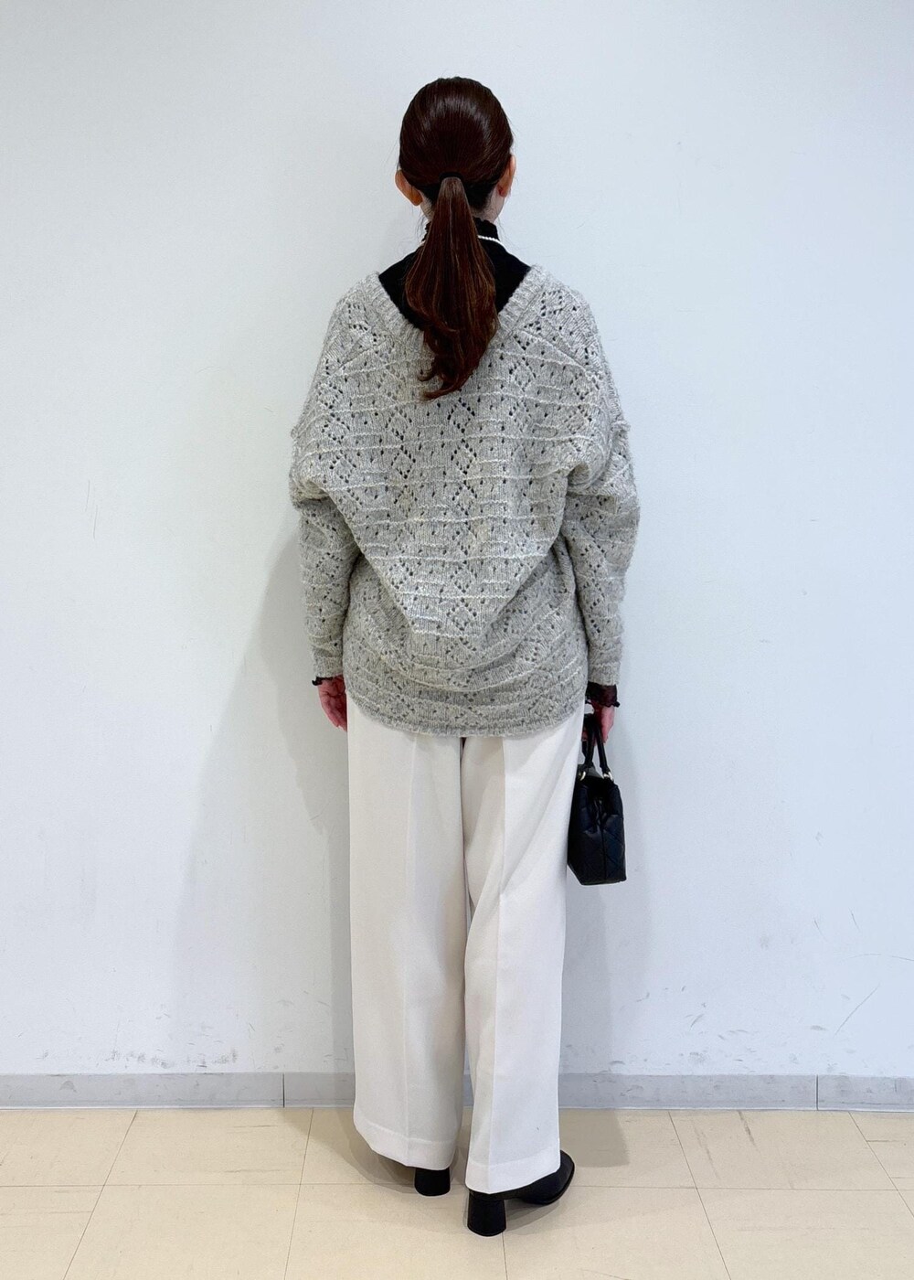 ブラック系のブーツ、ブラック系のTシャツ/カットソー、ベージュ系のニット/セーターを着用したレディースの冬コーディネートの4枚目の写真