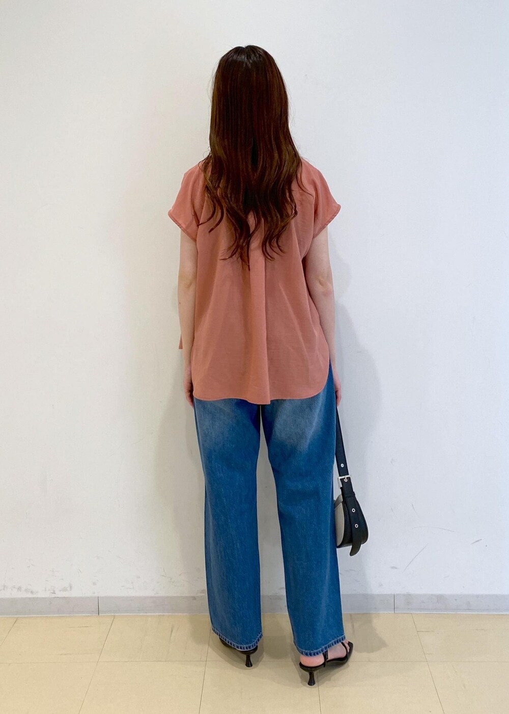 ブルー系のデニムパンツ、ブラック系のサンダル、ブラック系のキャミソールを着用したレディースの夏コーディネートの3枚目の写真