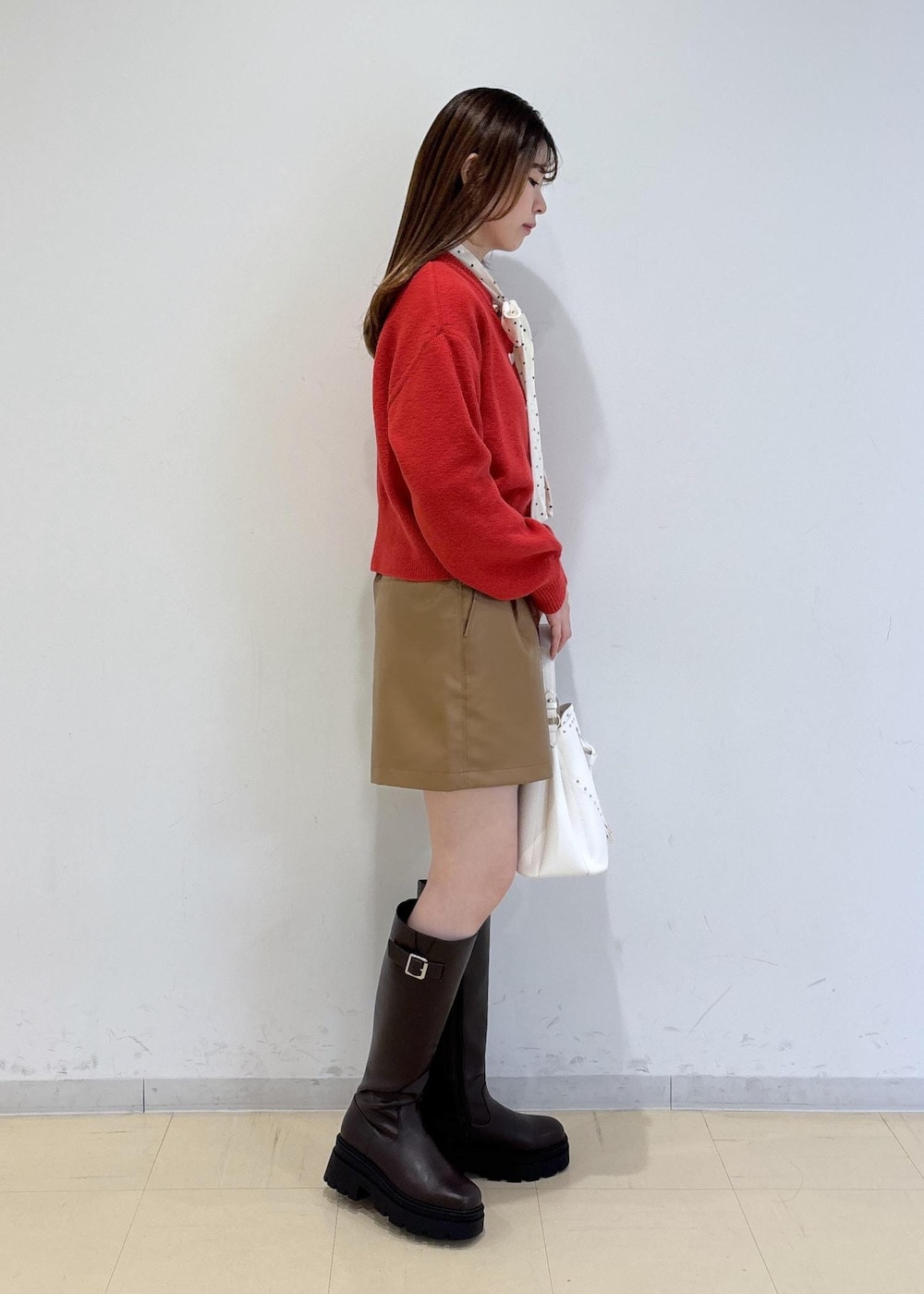 ブラウン系のブーツ、レッド系のカーディガン/ボレロ、ホワイト系のTシャツ/カットソーを着用したレディースの冬コーディネートの4枚目の写真