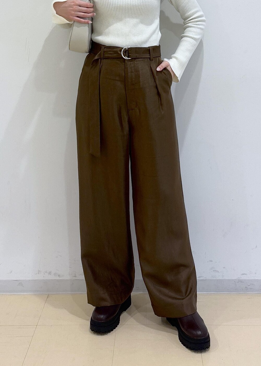 ブラウン系のブーツ、ピンク系のカーディガン/ボレロ、ホワイト系のニット/セーターを着用したレディースの冬コーディネートの9枚目の写真