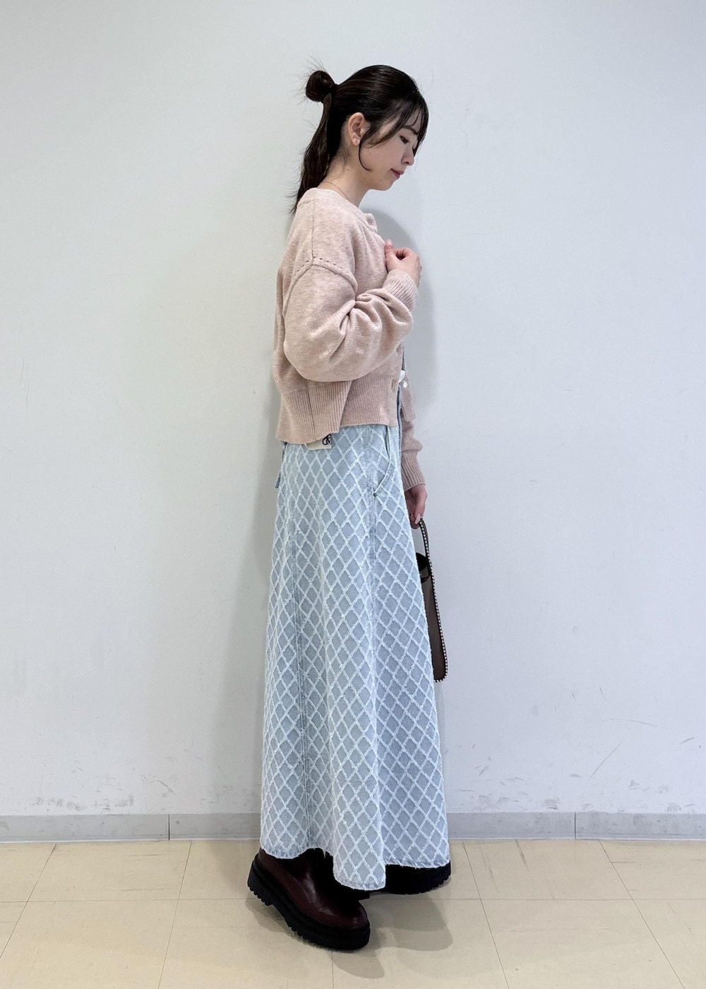 ブラウン系のブーツ、ピンク系のカーディガン/ボレロ、ブラウン系のトートバッグを着用したレディースの冬コーディネートの3枚目の写真