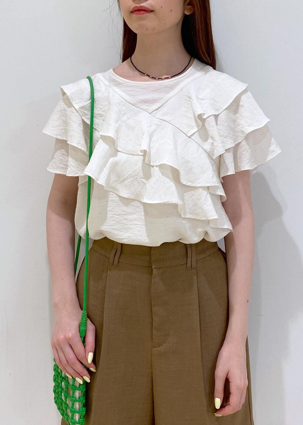 イエロー系のサンダル、ホワイト系のシャツ/ブラウス、グリーン系のショルダーバッグを着用したレディースの夏コーディネートの5枚目の写真