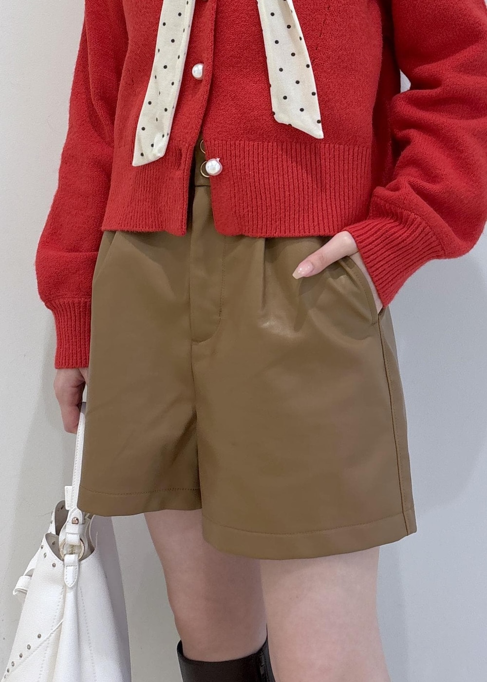 ブラウン系のブーツ、レッド系のカーディガン/ボレロ、ホワイト系のTシャツ/カットソーを着用したレディースの冬コーディネートの8枚目の写真