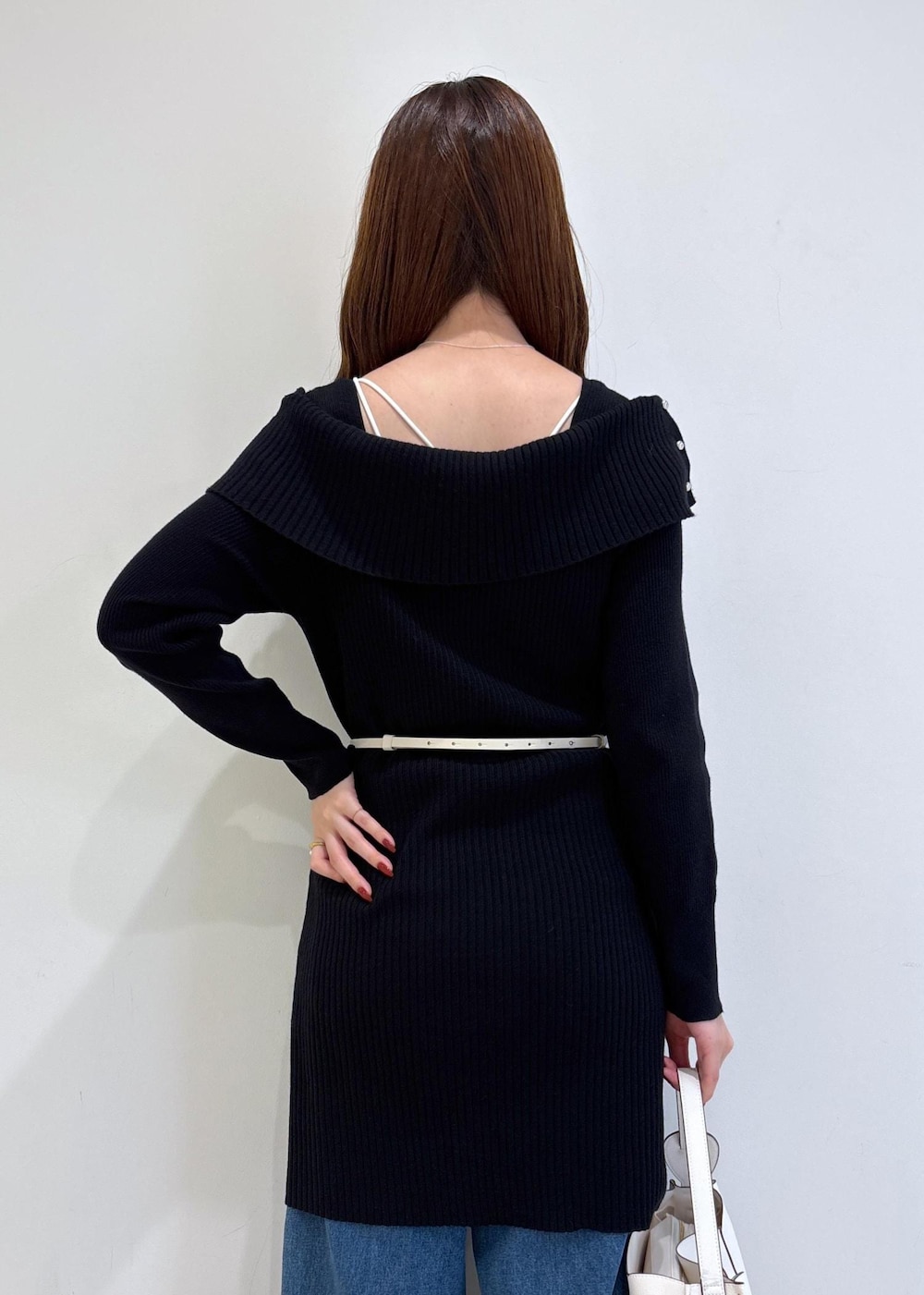 ブルー系のデニムパンツ、ブラック系のブーツ、ホワイト系のショルダーバッグを着用したレディースの秋コーディネートの7枚目の写真