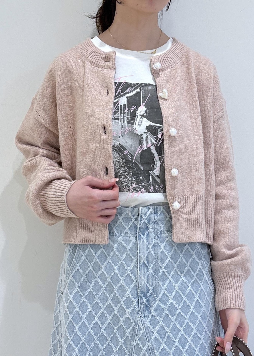 ブラウン系のブーツ、ピンク系のカーディガン/ボレロ、ブラウン系のトートバッグを着用したレディースの冬コーディネートの6枚目の写真