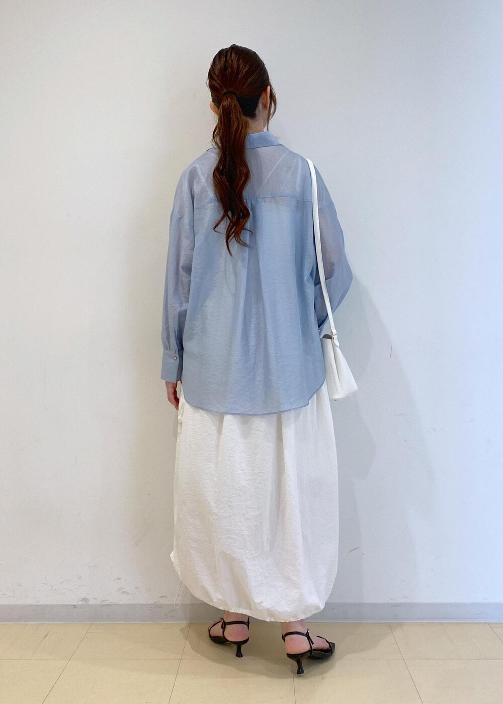 ブラック系のサンダル、ホワイト系のワンピース、ブルー系のシャツ/ブラウスを着用したレディースの夏コーディネートの4枚目の写真