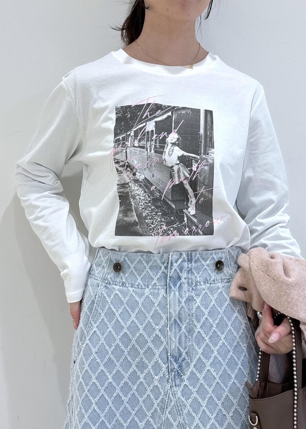 ブラウン系のブーツ、ピンク系のカーディガン/ボレロ、ブラウン系のトートバッグを着用したレディースの冬コーディネートの7枚目の写真