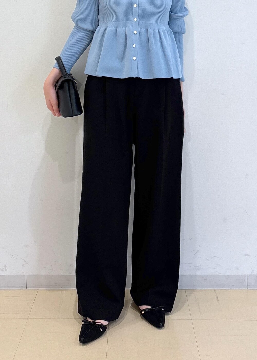 ブラック系のショルダーバッグ、ブラック系のパンプス、ブルー系のカーディガン/ボレロを着用したレディースの秋コーディネートの6枚目の写真