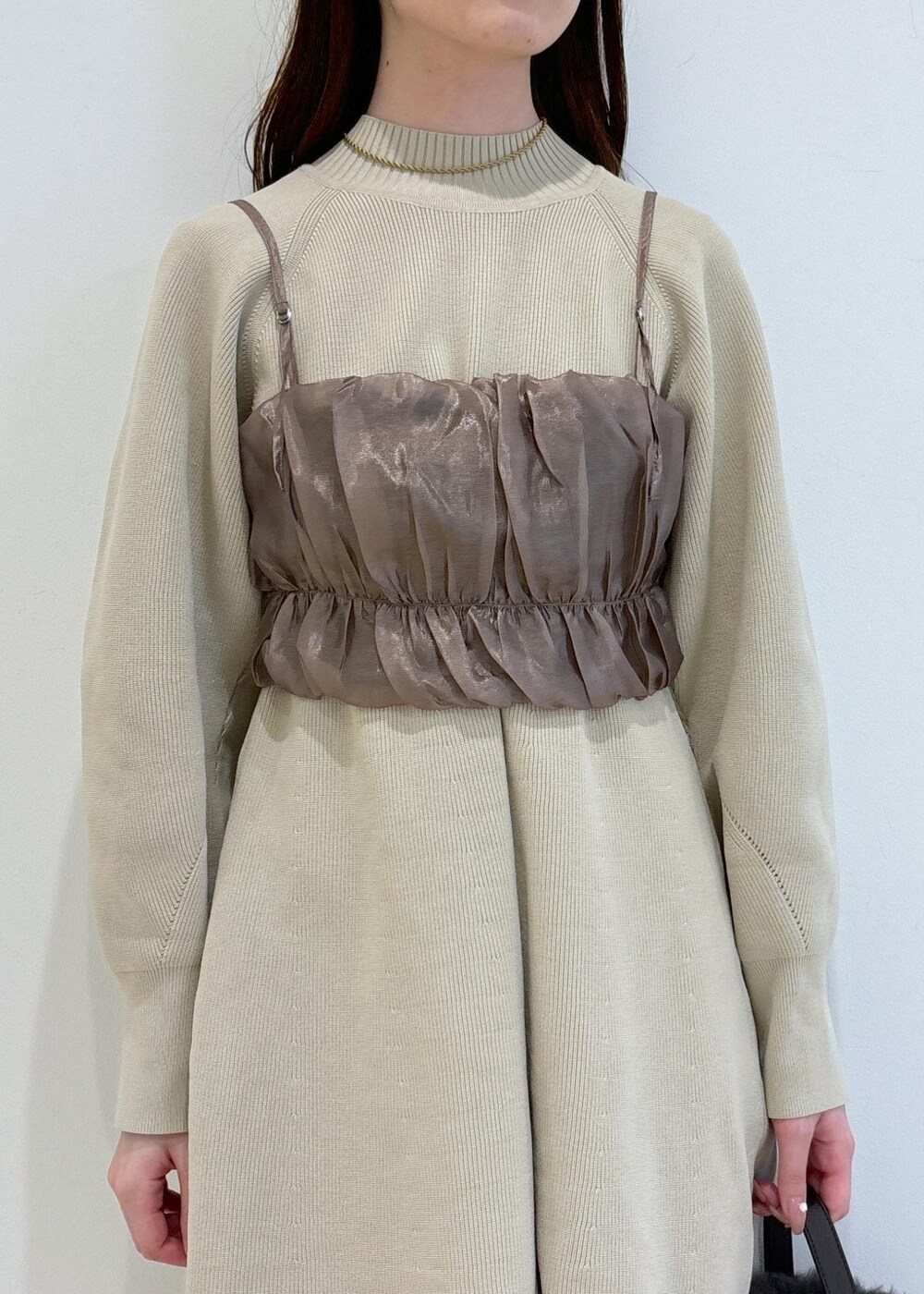 ブラウン系のブーツ、グレー系のショルダーバッグ、ベージュ系のキャミソールを着用したレディースの秋コーディネートの7枚目の写真