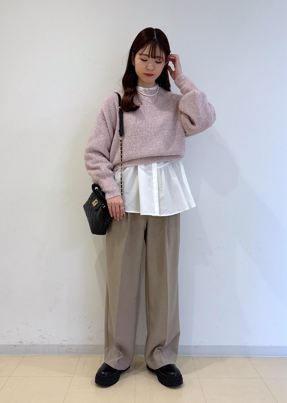 ブラック系のブーツ、ホワイト系のシャツ/ブラウス、ピンク系のニット/セーターを着用したレディースの冬コーディネートの2枚目の写真