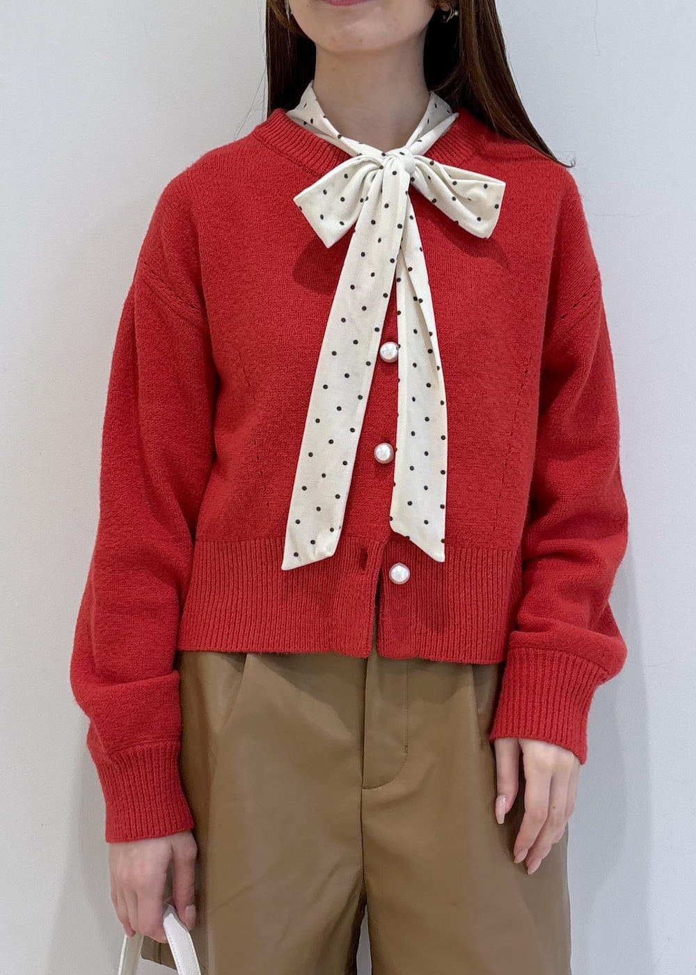 ブラウン系のブーツ、レッド系のカーディガン/ボレロ、ホワイト系のTシャツ/カットソーを着用したレディースの冬コーディネートの6枚目の写真