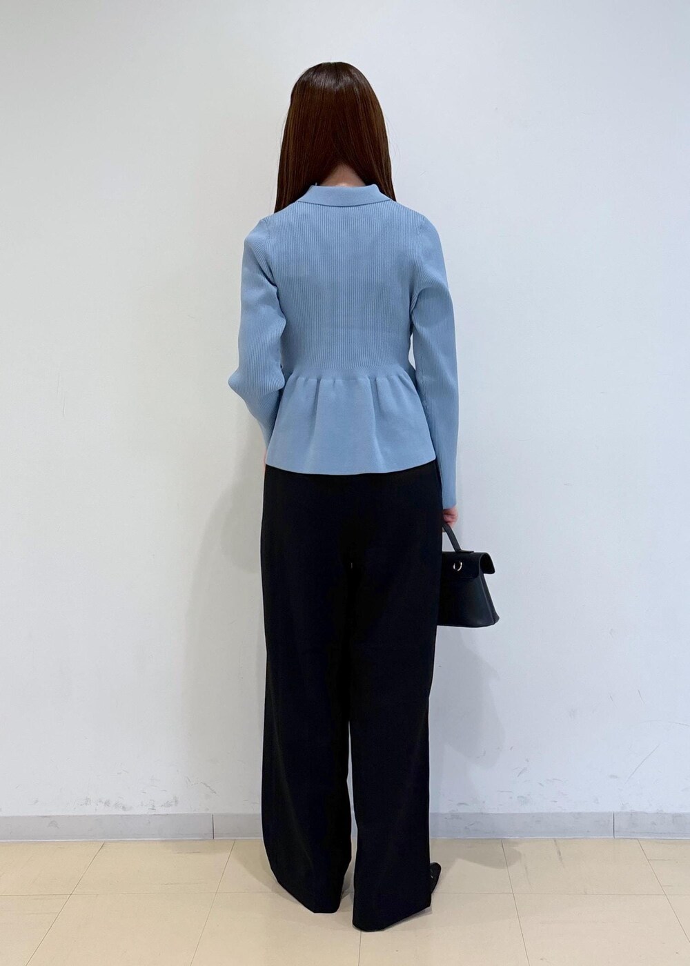 ブラック系のショルダーバッグ、ブラック系のパンプス、ブルー系のカーディガン/ボレロを着用したレディースの秋コーディネートの4枚目の写真