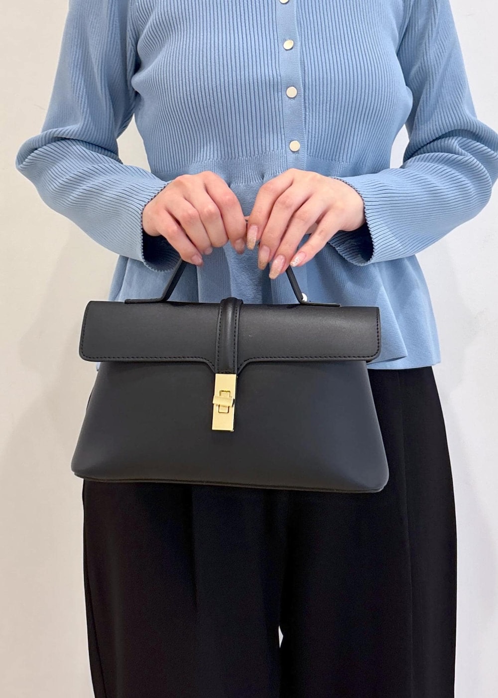 ブラック系のショルダーバッグ、ブラック系のパンプス、ブルー系のカーディガン/ボレロを着用したレディースの秋コーディネートの10枚目の写真