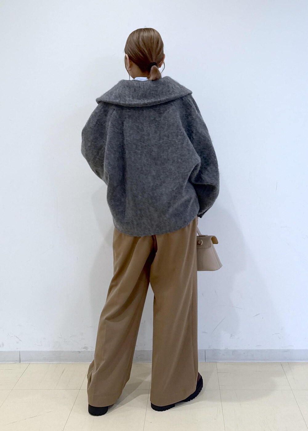 ベージュ系のショルダーバッグ、ブラウン系のブーツ、ブラウン系のTシャツ/カットソーを着用したレディースの秋コーディネートの3枚目の写真