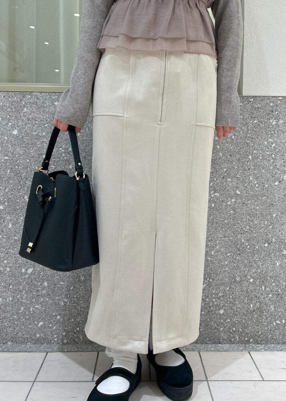 ベージュ系のスカート、グレー系のニット/セーター、ブラウン系のその他アウターを着用したレディースの冬コーディネートの9枚目の写真