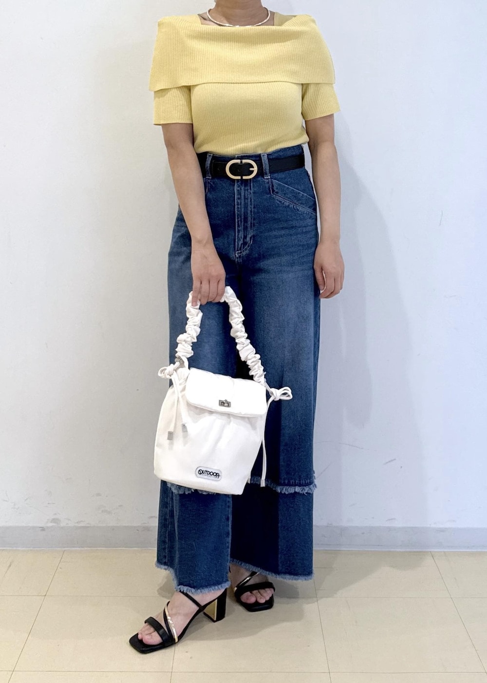 ブラック系のサンダル、ブルー系のデニムパンツ、イエロー系のニット/セーターを着用したレディースの夏コーディネートの2枚目の写真