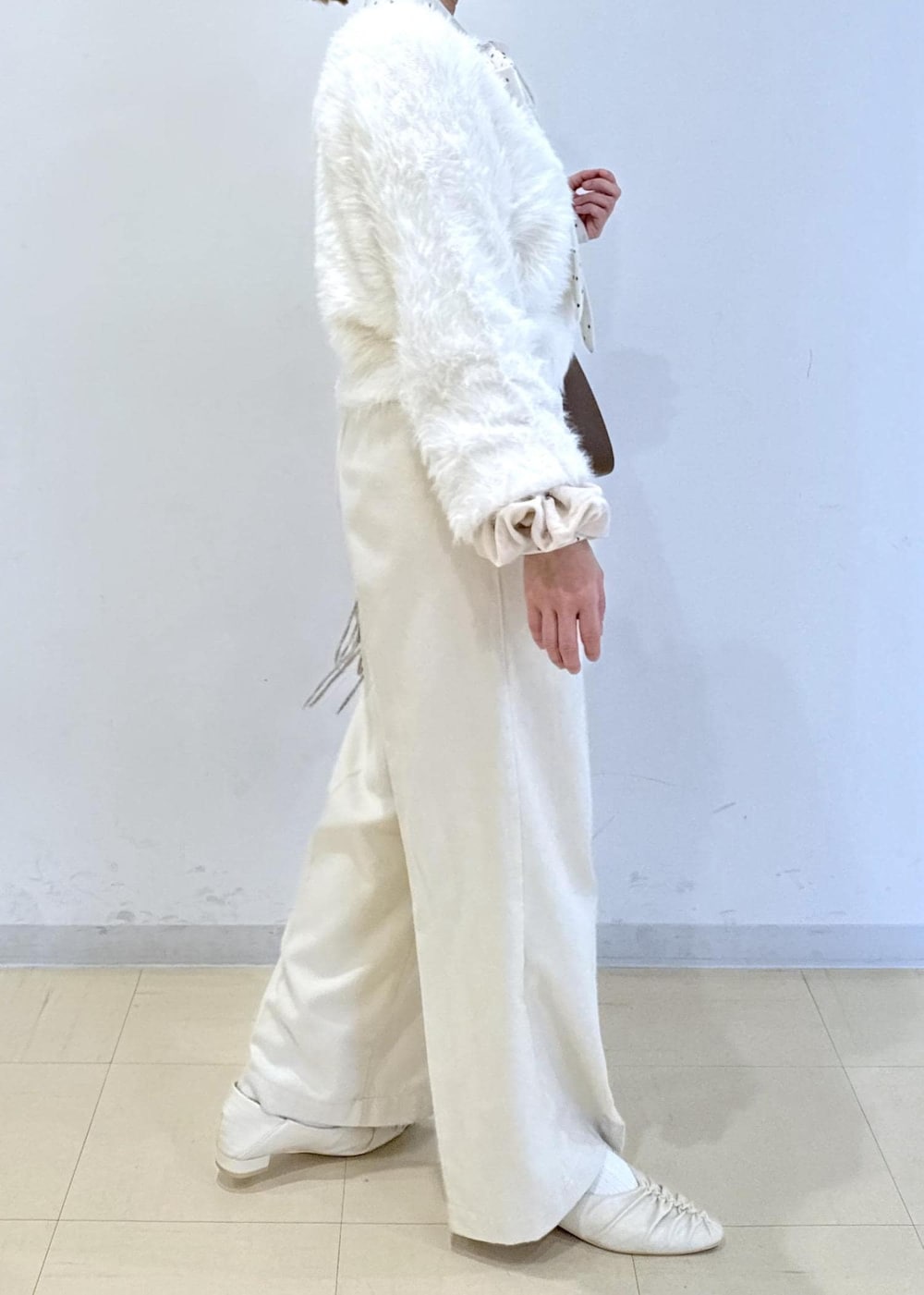 ブラウン系のショルダーバッグ、ホワイト系のパンプス、ホワイト系のカーディガン/ボレロを着用したレディースの冬コーディネートの4枚目の写真