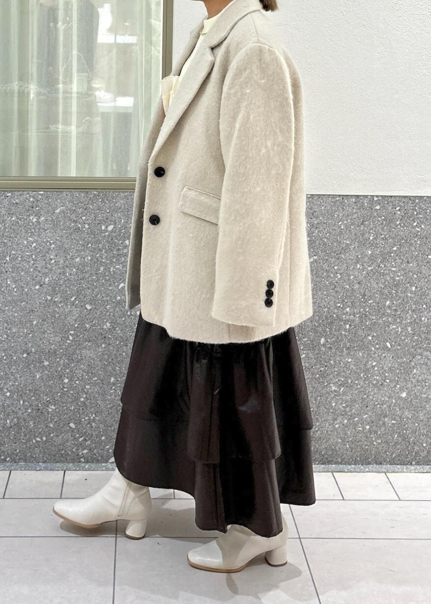 ホワイト系のブーツ、ベージュ系のスカート、ホワイト系のニット/セーターを着用したレディースの秋コーディネートの4枚目の写真