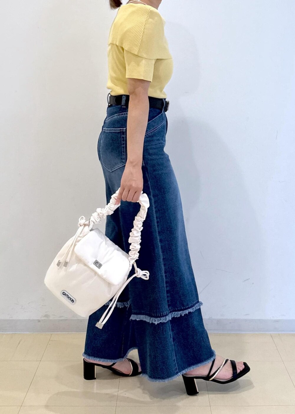 ブラック系のサンダル、ブルー系のデニムパンツ、イエロー系のニット/セーターを着用したレディースの夏コーディネートの5枚目の写真