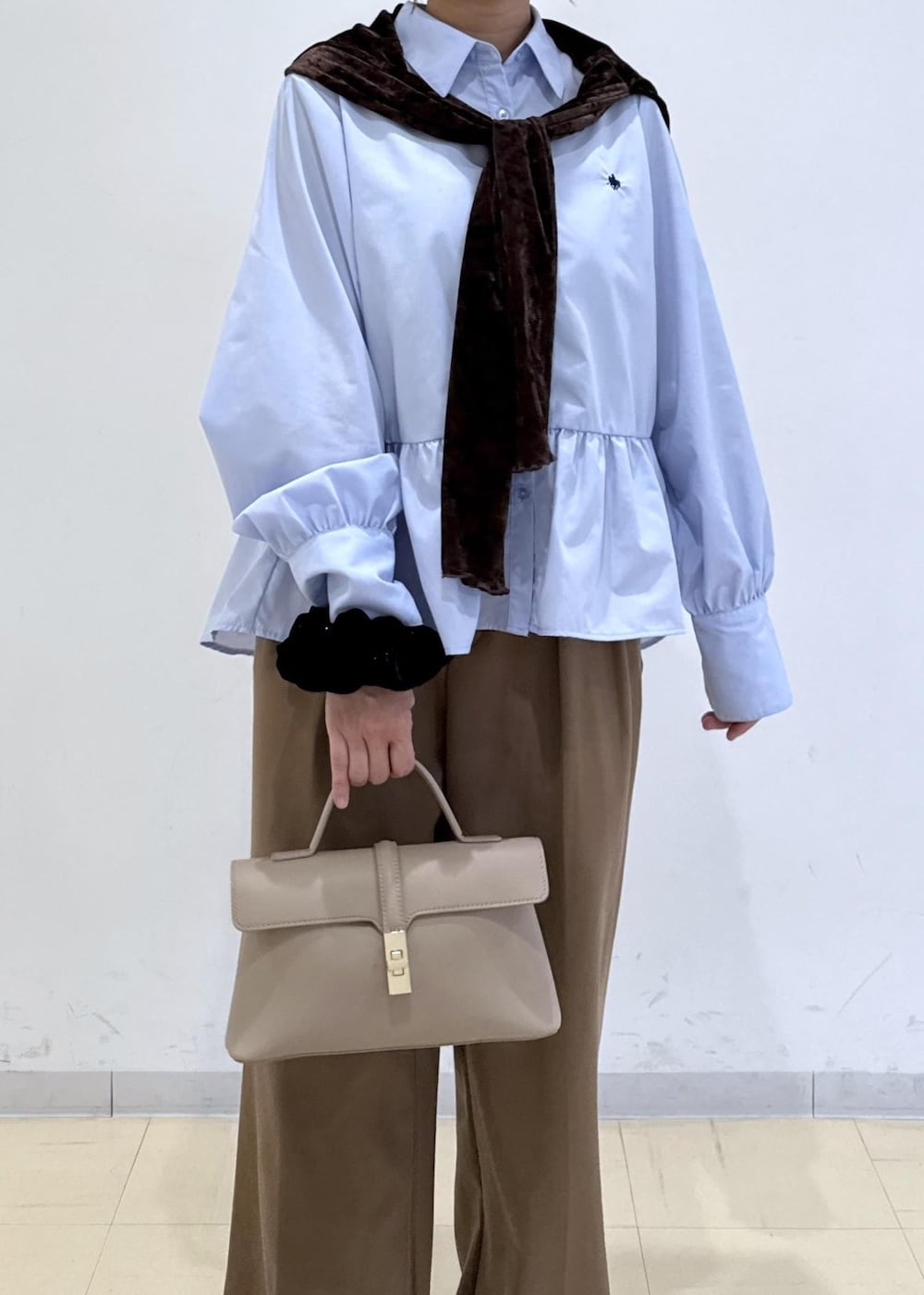 ベージュ系のショルダーバッグ、ブラウン系のブーツ、ブラウン系のTシャツ/カットソーを着用したレディースの秋コーディネートの5枚目の写真