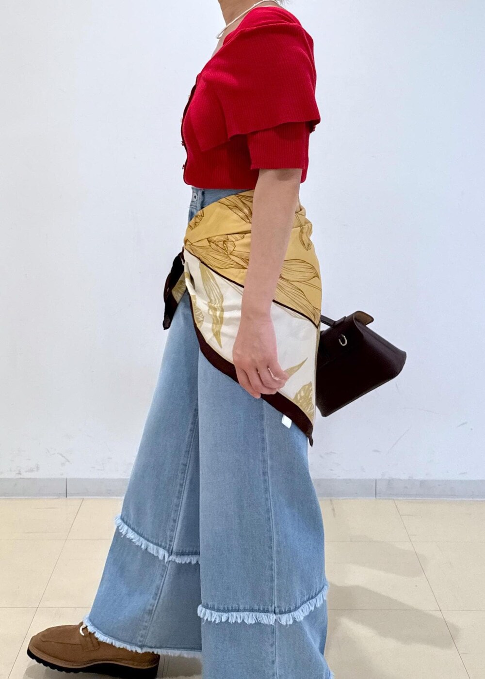 ブラウン系のショルダーバッグ、ベージュ系のローファー、レッド系のニット/セーターを着用したレディースの秋コーディネートの9枚目の写真