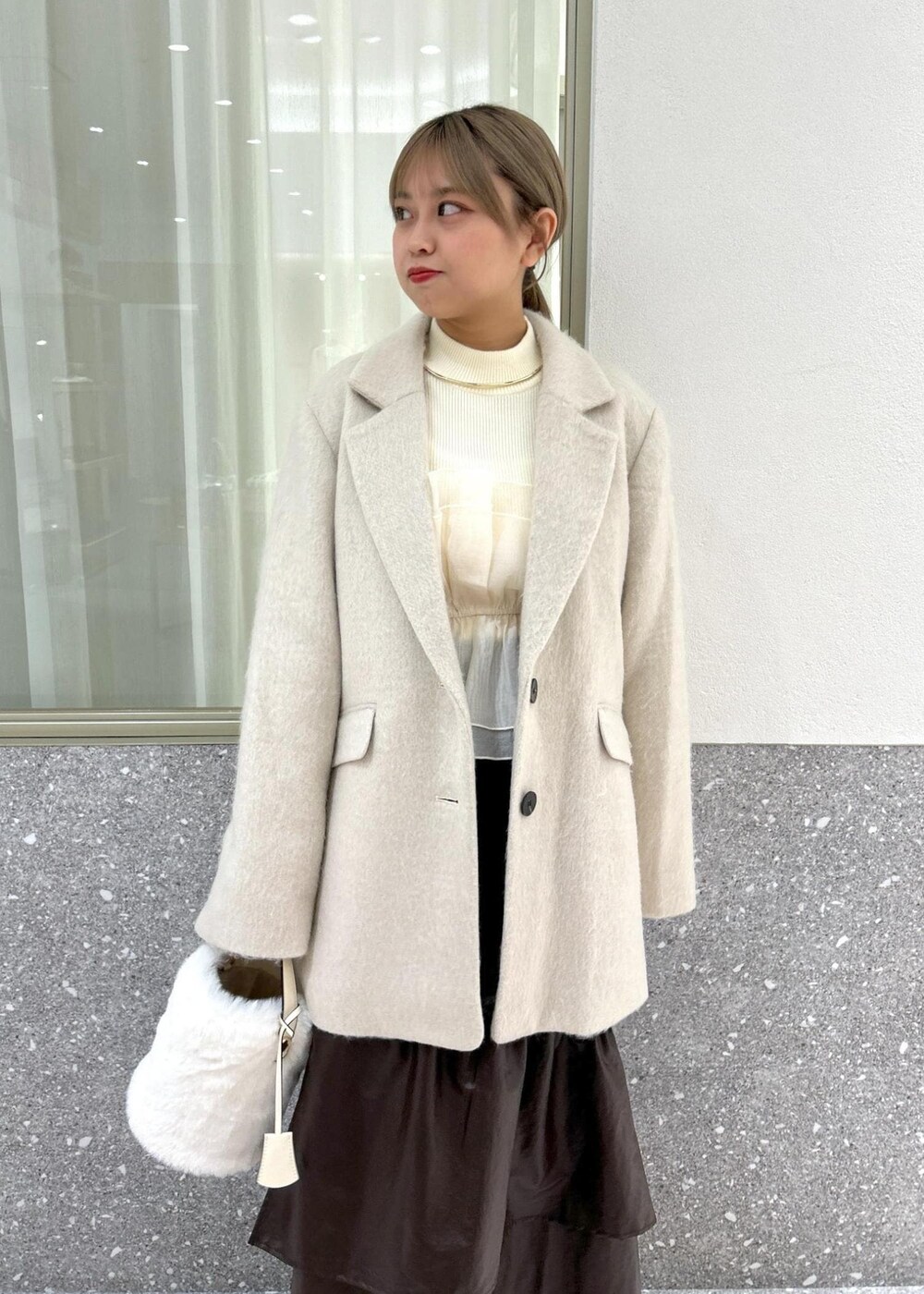 ホワイト系のブーツ、ベージュ系のスカート、ホワイト系のニット/セーターを着用したレディースの秋コーディネートの8枚目の写真