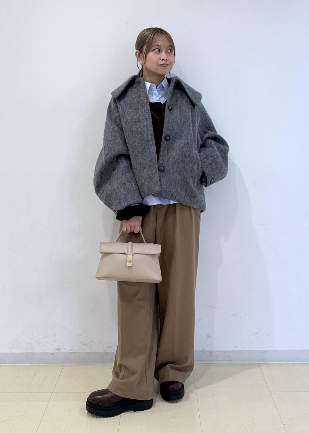 ベージュ系のショルダーバッグ、ブラウン系のブーツ、ブラウン系のTシャツ/カットソーを着用したレディースの秋コーディネートの9枚目の写真