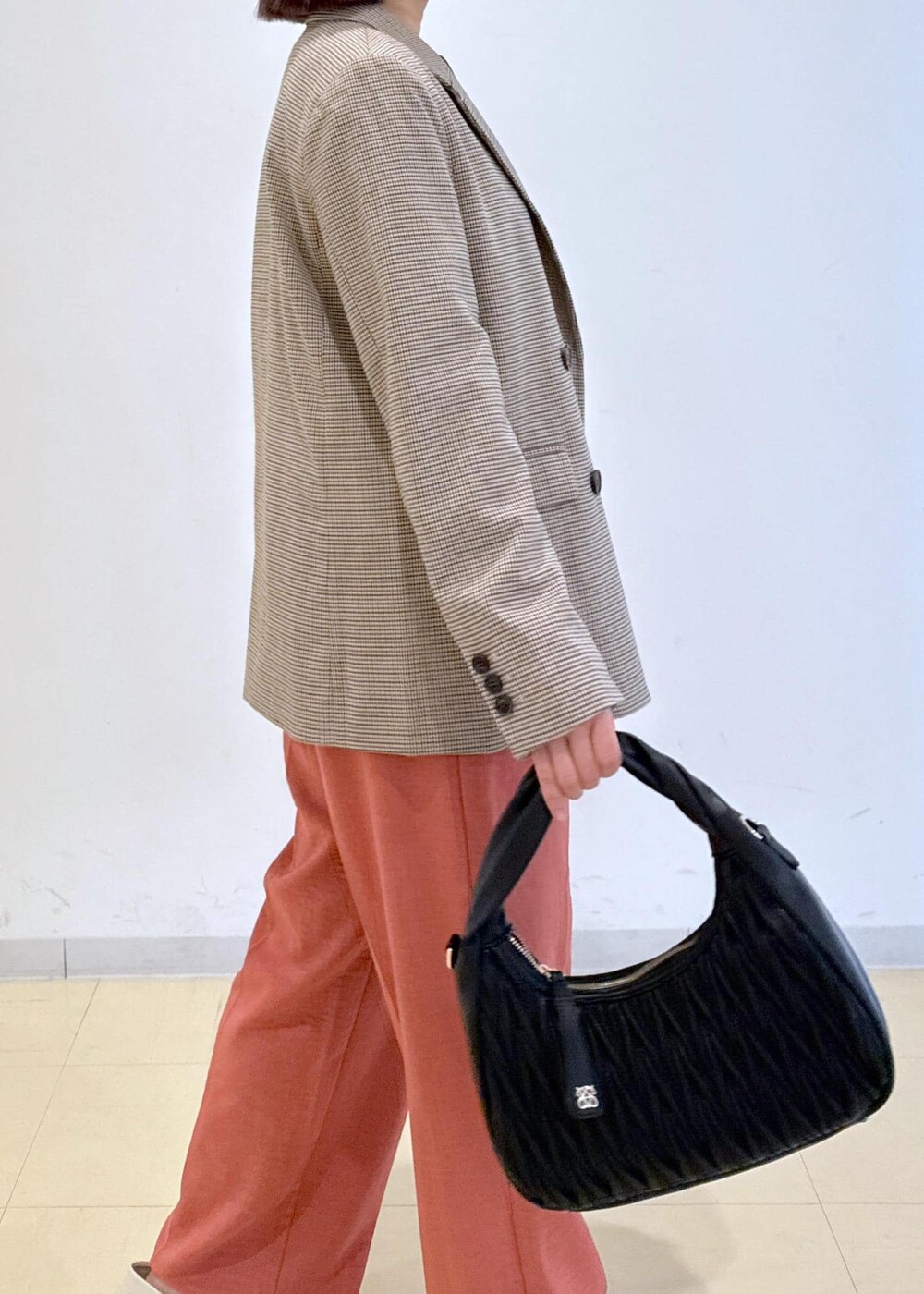 オレンジ系のスラックス、ベージュ系のテーラードジャケット、ホワイト系のTシャツ/カットソーを着用したレディースの秋コーディネートの7枚目の写真