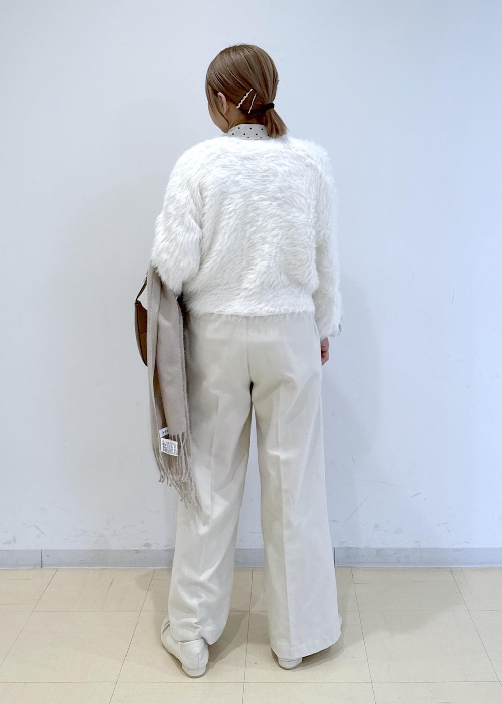 ブラウン系のショルダーバッグ、ホワイト系のパンプス、ホワイト系のカーディガン/ボレロを着用したレディースの冬コーディネートの3枚目の写真