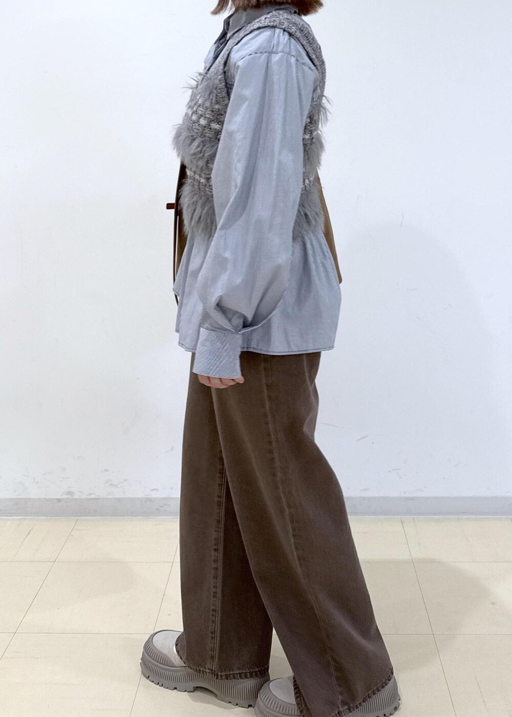 ブラウン系のショルダーバッグ、ブラウン系のデニムパンツ、ブルー系のシャツ/ブラウスを着用したレディースの秋コーディネートの9枚目の写真