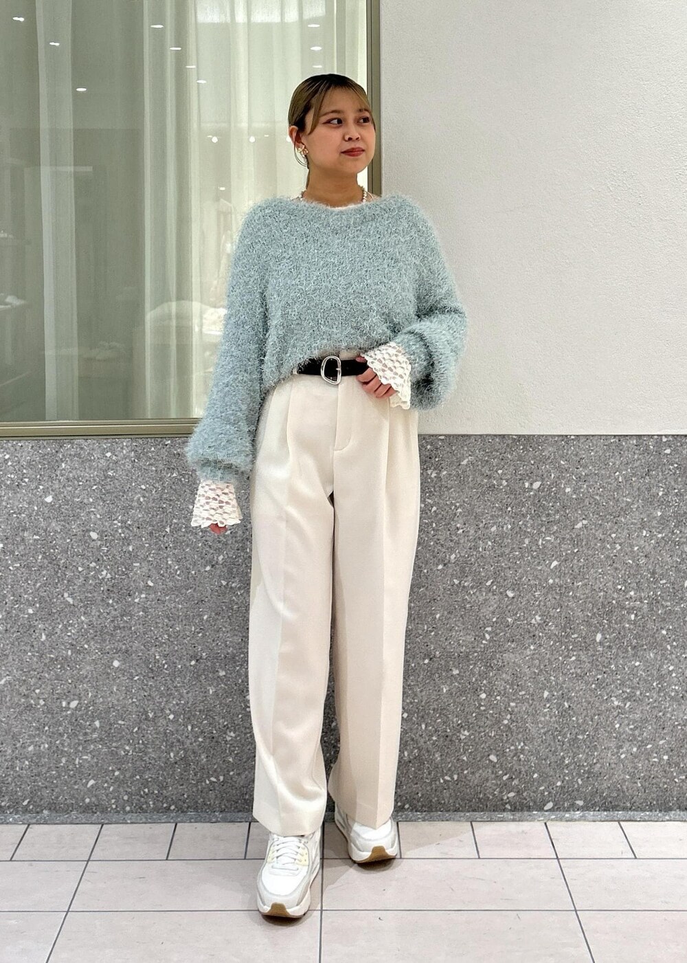 グリーン系のニット/セーター、ホワイト系のTシャツ/カットソー、シルバー系のショルダーバッグを着用したレディースの冬コーディネートの6枚目の写真