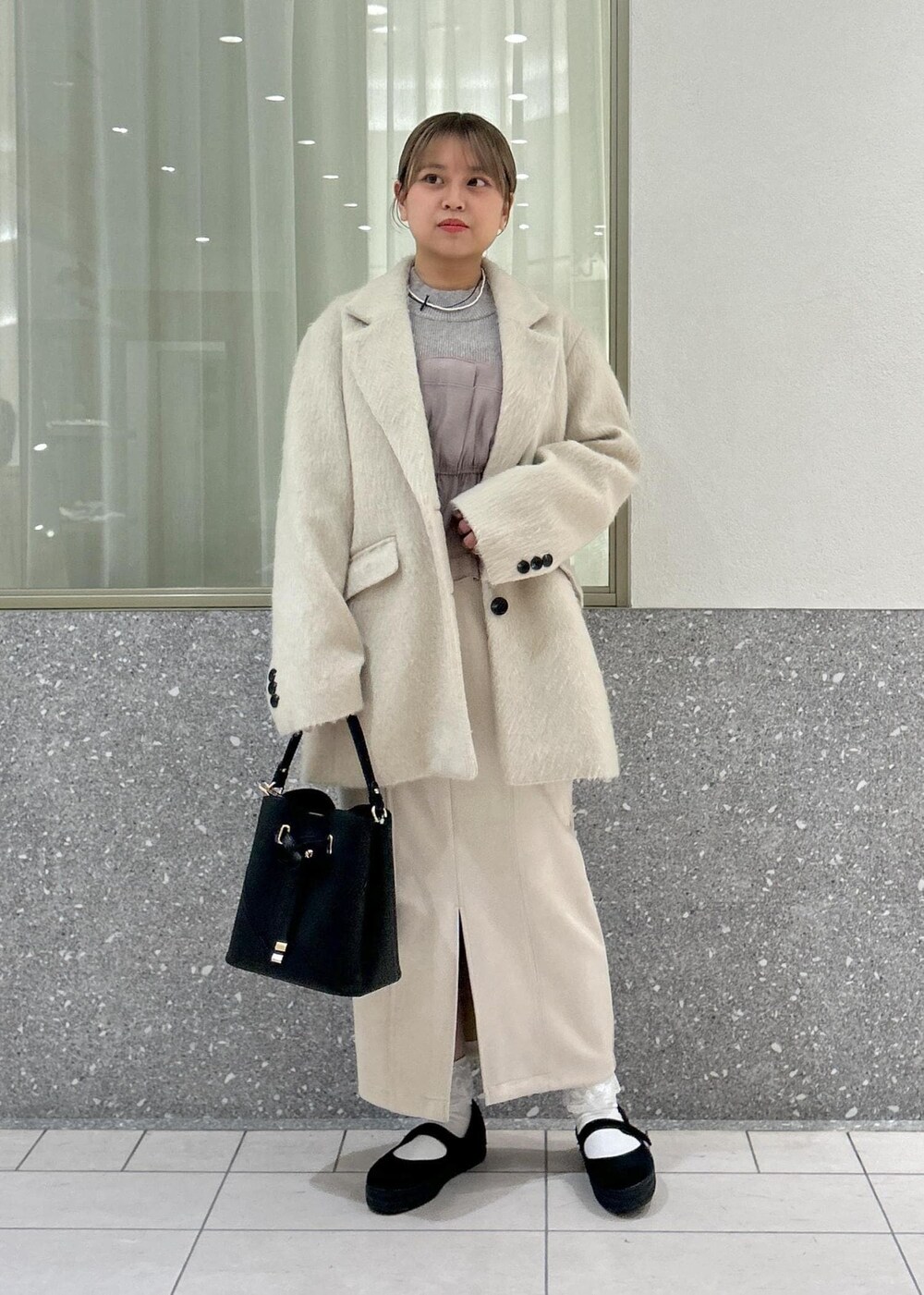 ベージュ系のスカート、グレー系のニット/セーター、ブラウン系のその他アウターを着用したレディースの冬コーディネートの6枚目の写真