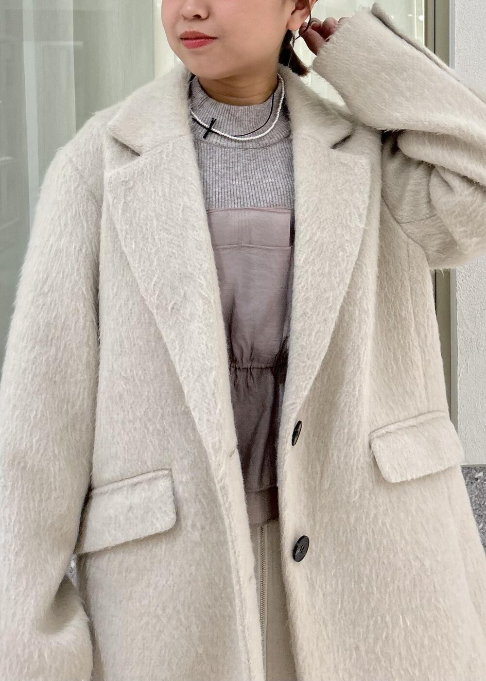 ベージュ系のスカート、グレー系のニット/セーター、ブラウン系のその他アウターを着用したレディースの冬コーディネートの7枚目の写真