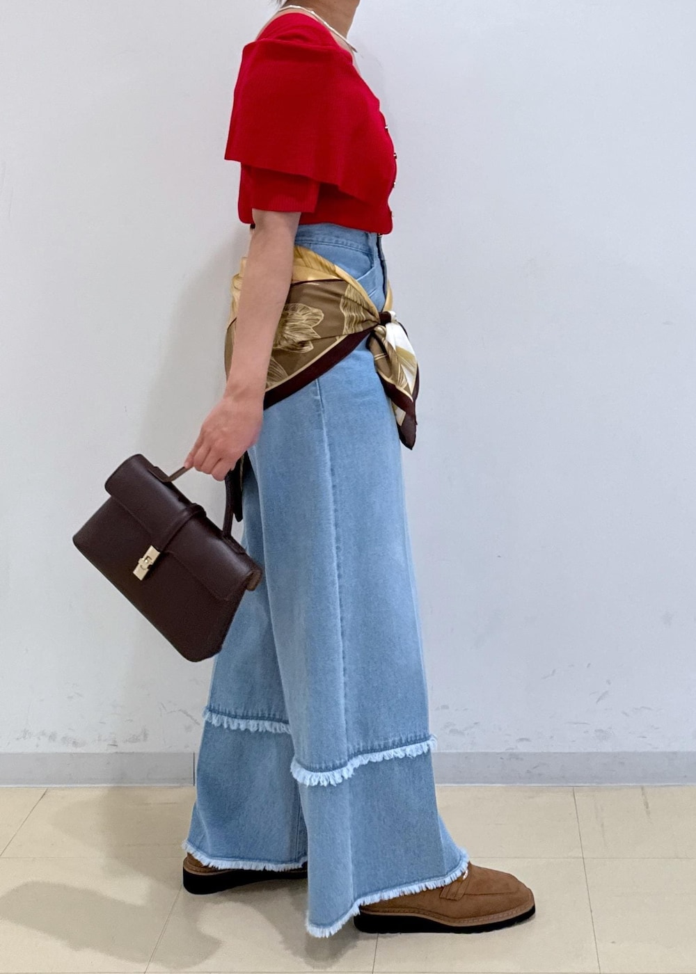 ブラウン系のショルダーバッグ、ベージュ系のローファー、レッド系のニット/セーターを着用したレディースの秋コーディネートの3枚目の写真