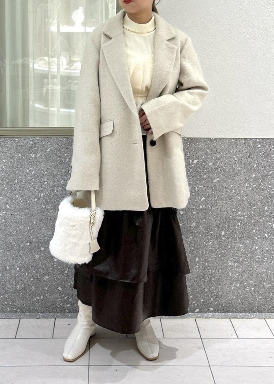ホワイト系のブーツ、ベージュ系のスカート、ホワイト系のニット/セーターを着用したレディースの秋コーディネートの7枚目の写真