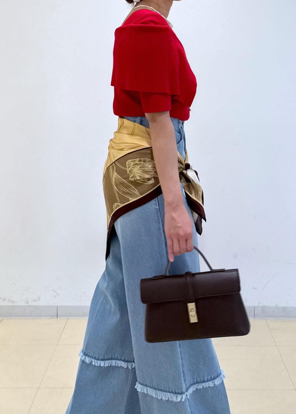 ブラウン系のショルダーバッグ、ベージュ系のローファー、レッド系のニット/セーターを着用したレディースの秋コーディネートの7枚目の写真