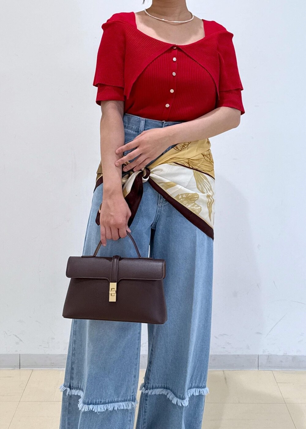 ブラウン系のショルダーバッグ、ベージュ系のローファー、レッド系のニット/セーターを着用したレディースの秋コーディネートの6枚目の写真