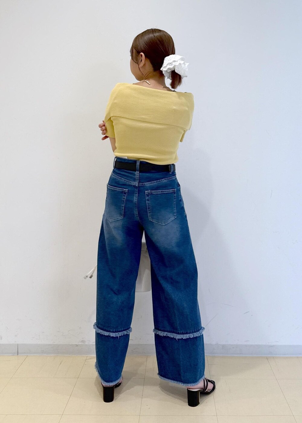 ブラック系のサンダル、ブルー系のデニムパンツ、イエロー系のニット/セーターを着用したレディースの夏コーディネートの4枚目の写真